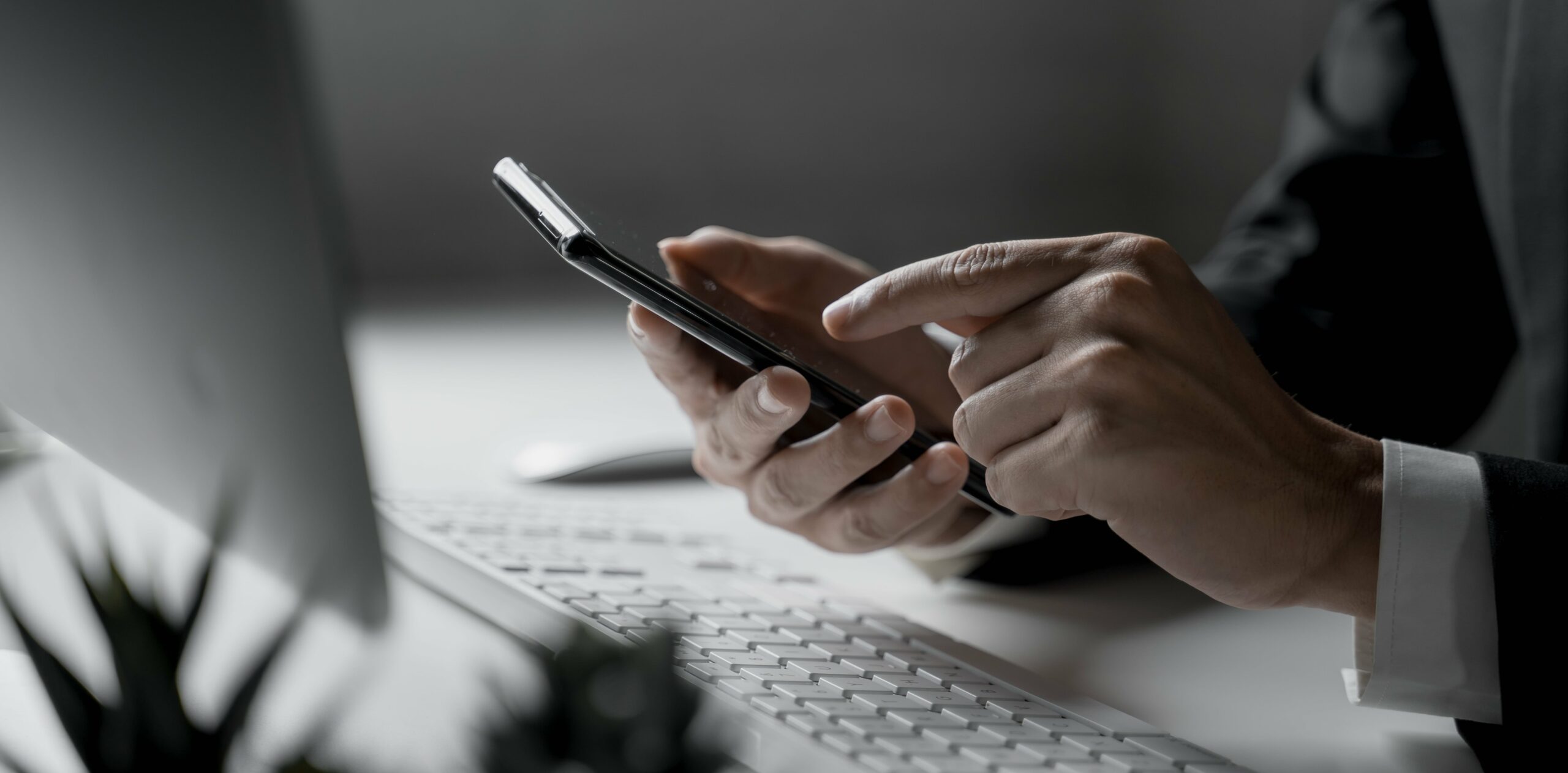 Mężczyzna trzymający smartphone w ręku w celu skontaktowania się z zespołem serwisu ocśrodowiskowe.pl.
